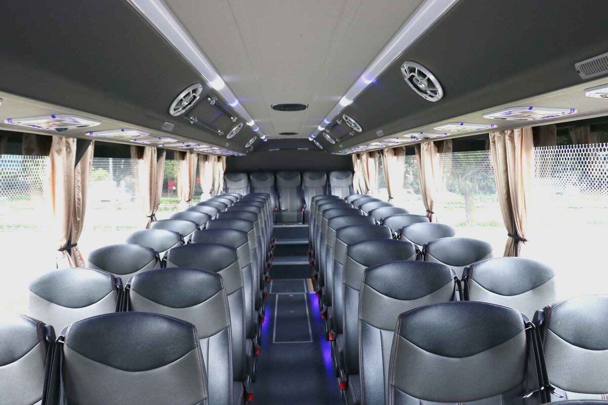 Inside a Season Bus coach: clean rows of seats down a lit aisle